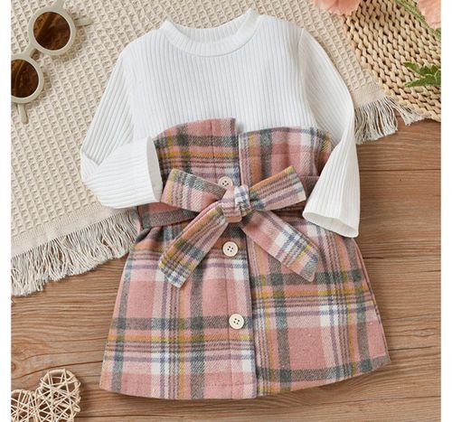 White knit top with pink plaid bow detail and button accents.