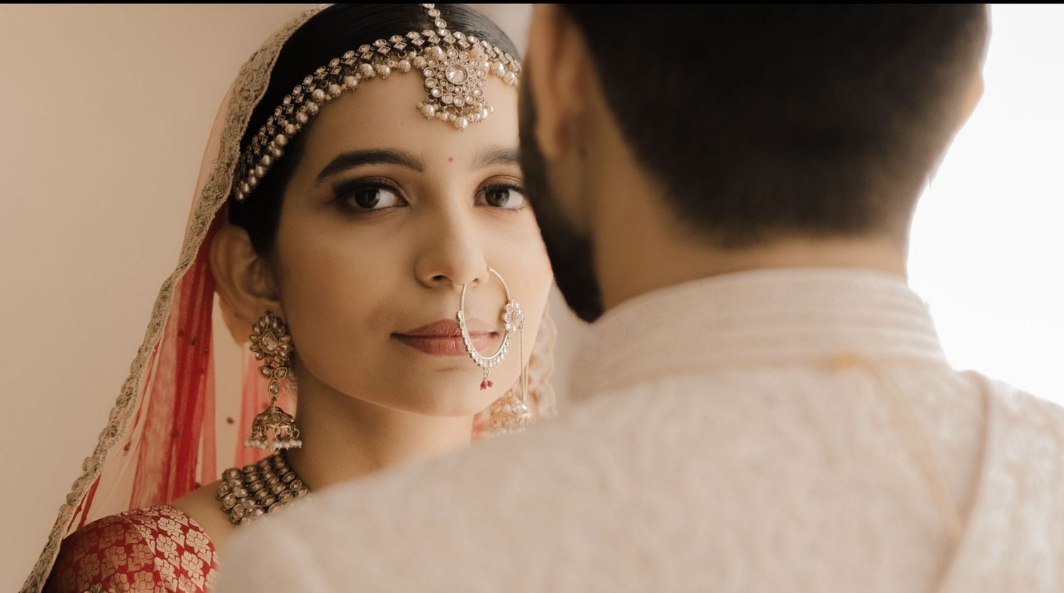 Traditional Indian bridal jewelry and accessories displayed in a close-up view of ornate gold and red details.