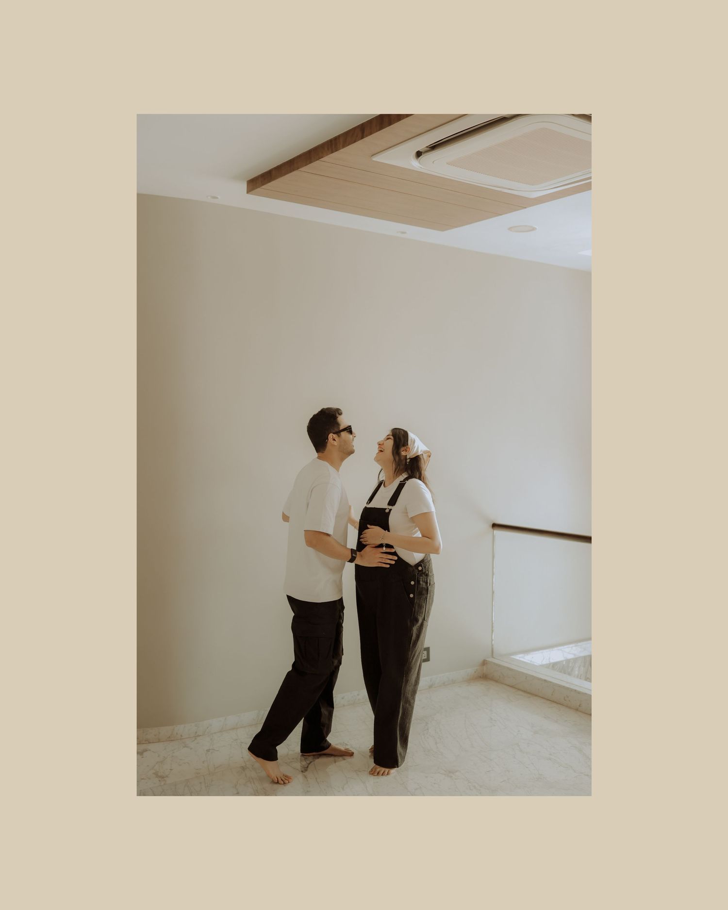 Two people in black outfits dance together in a minimalist white studio space.