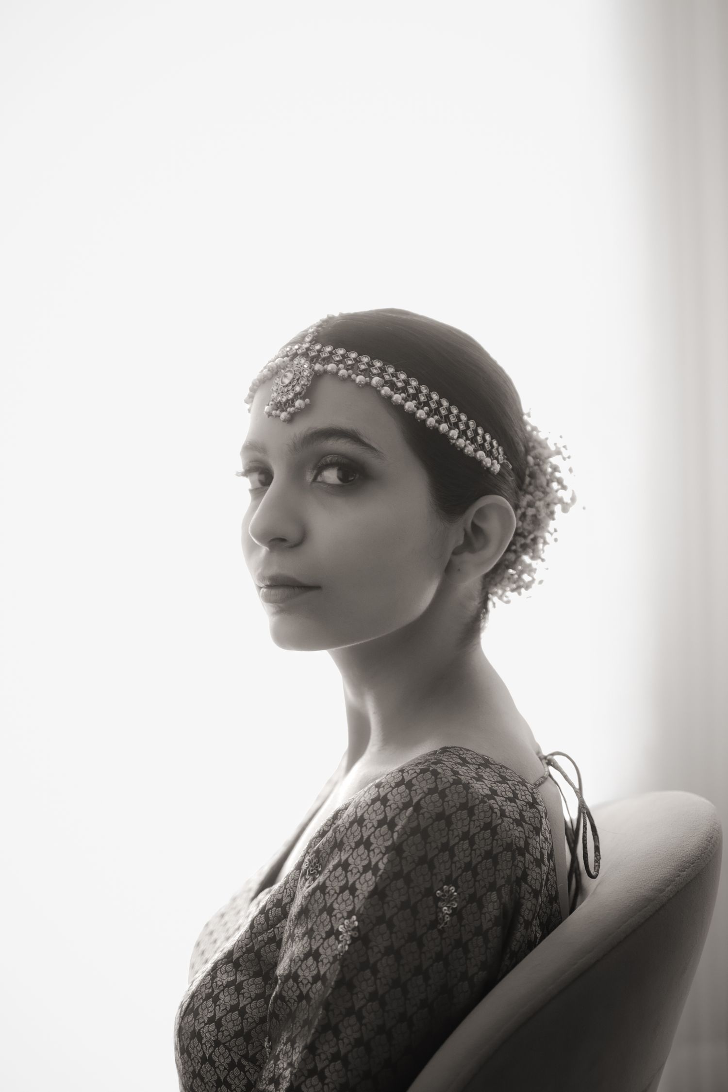 Elegant black and white portraits showcasing intricate bridal headpieces and jewelry in profile view.