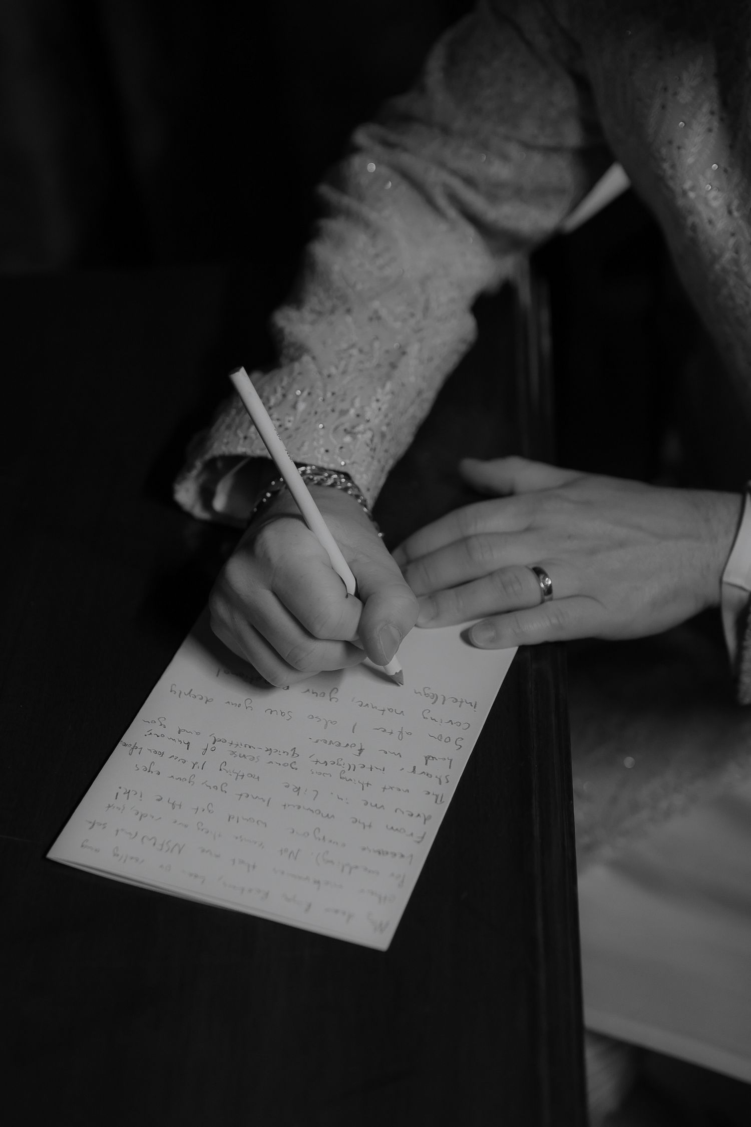 A hand writes with a pen on white paper in a series of black and white photographs showing the writing process.