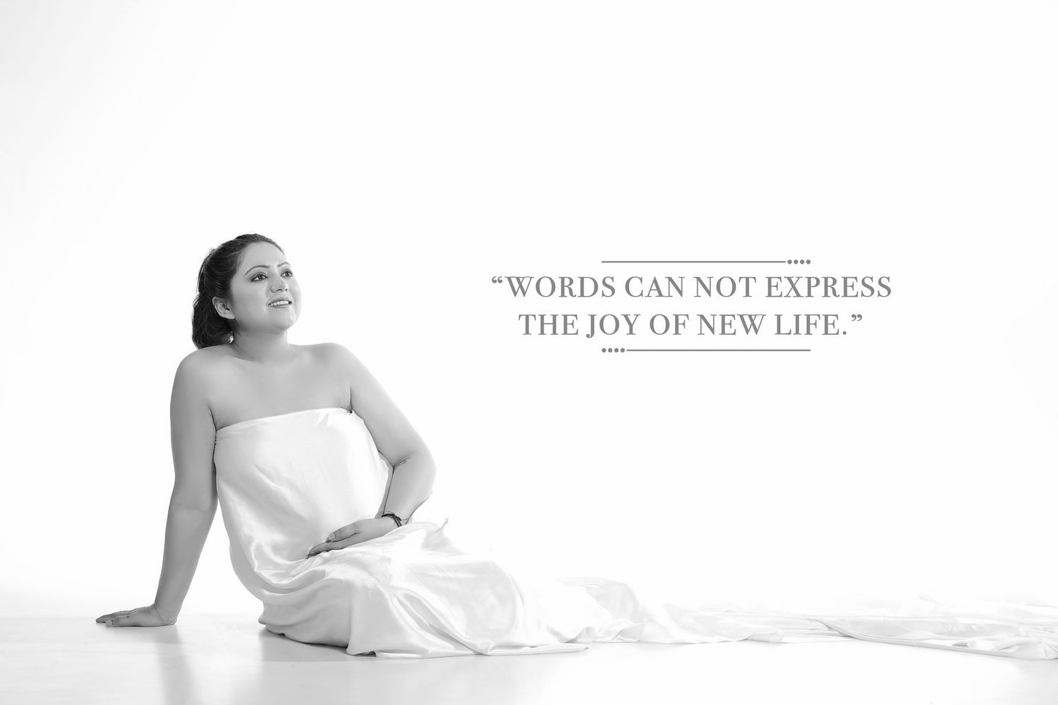 High-key maternity portrait with inspirational quote about new life.