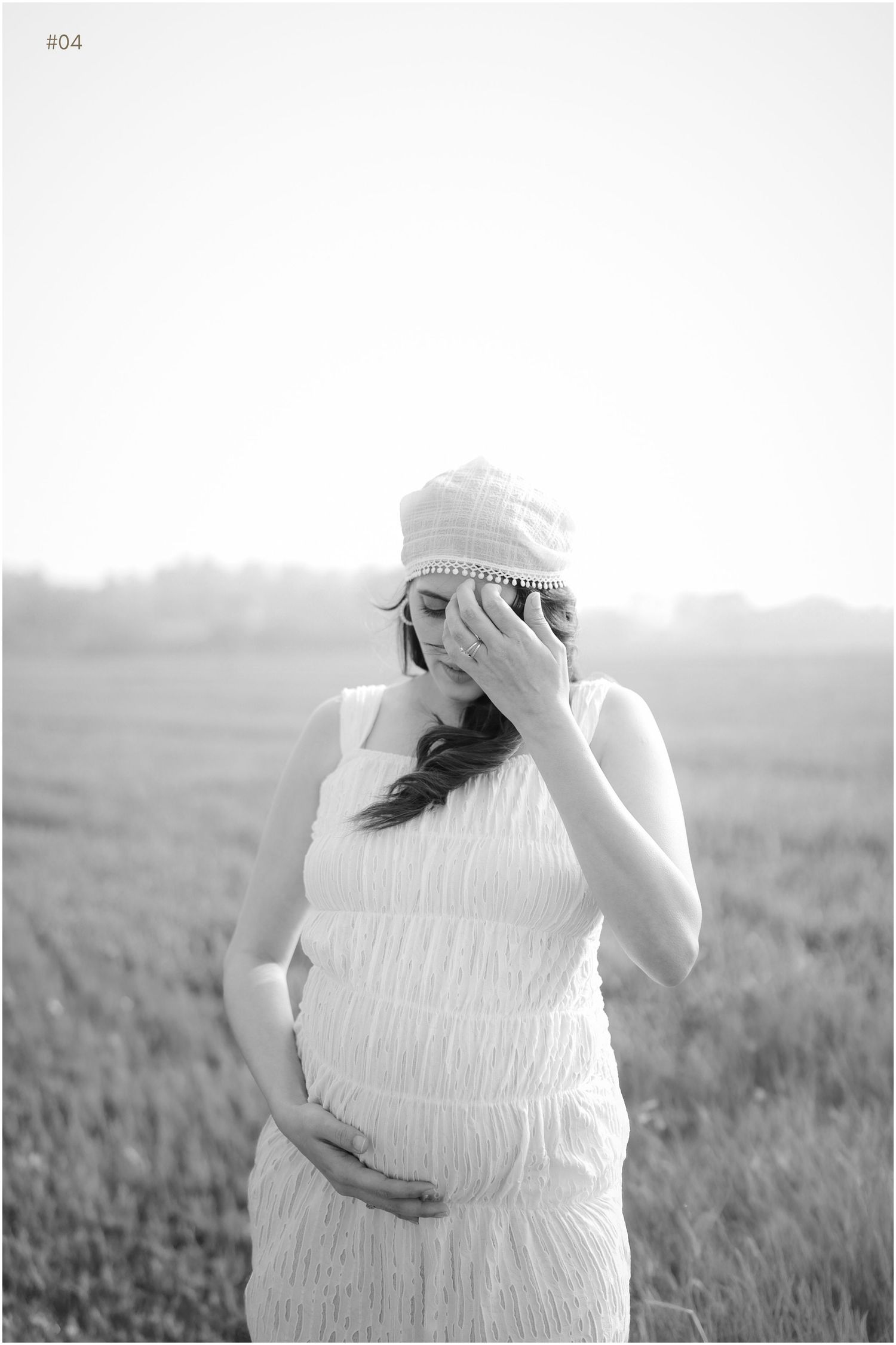 Black and white maternity photos show a woman in a white dress cradling her baby bump in a serene field.