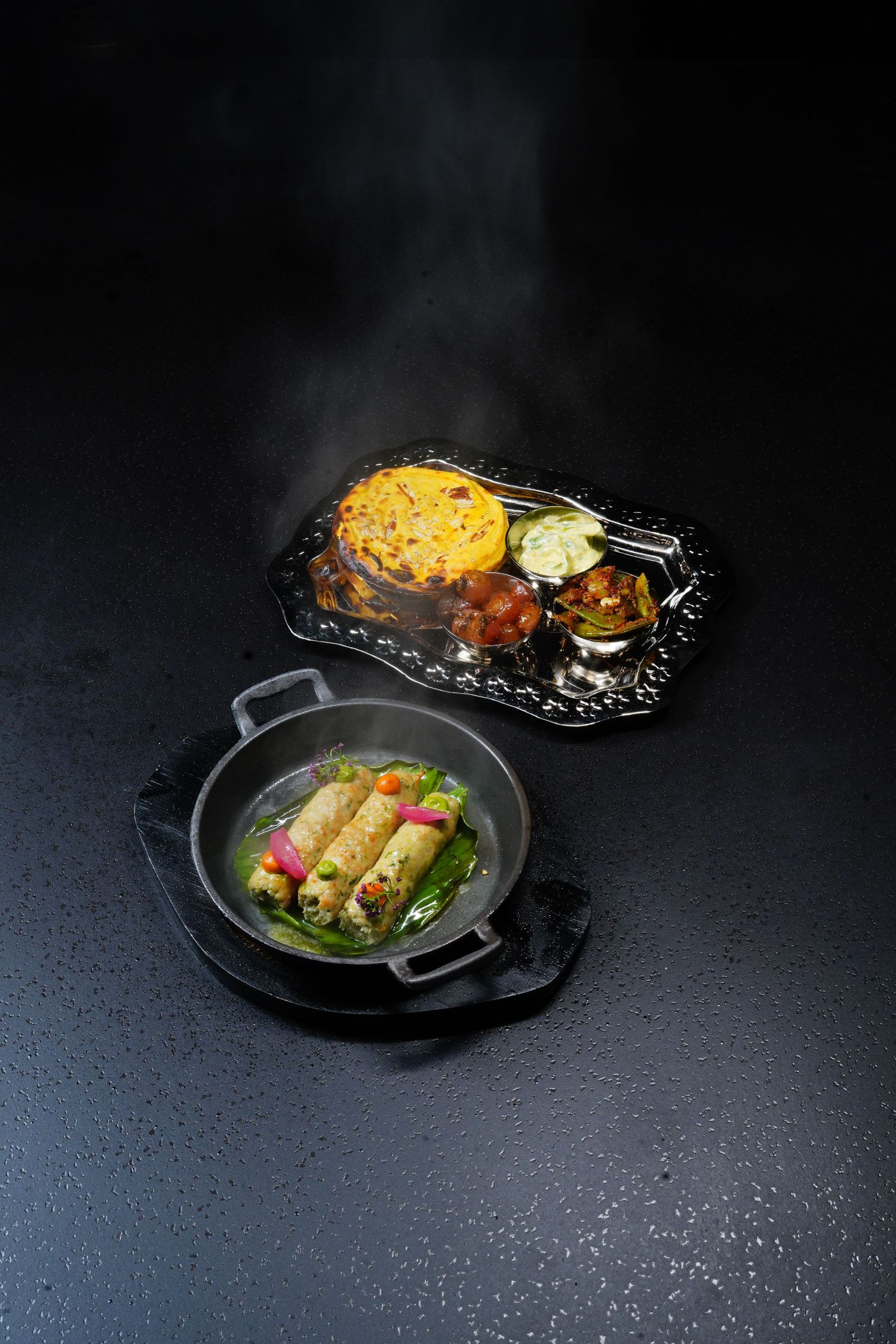 Dark plated food photography series featuring elegantly presented dishes on black tableware against a moody background.