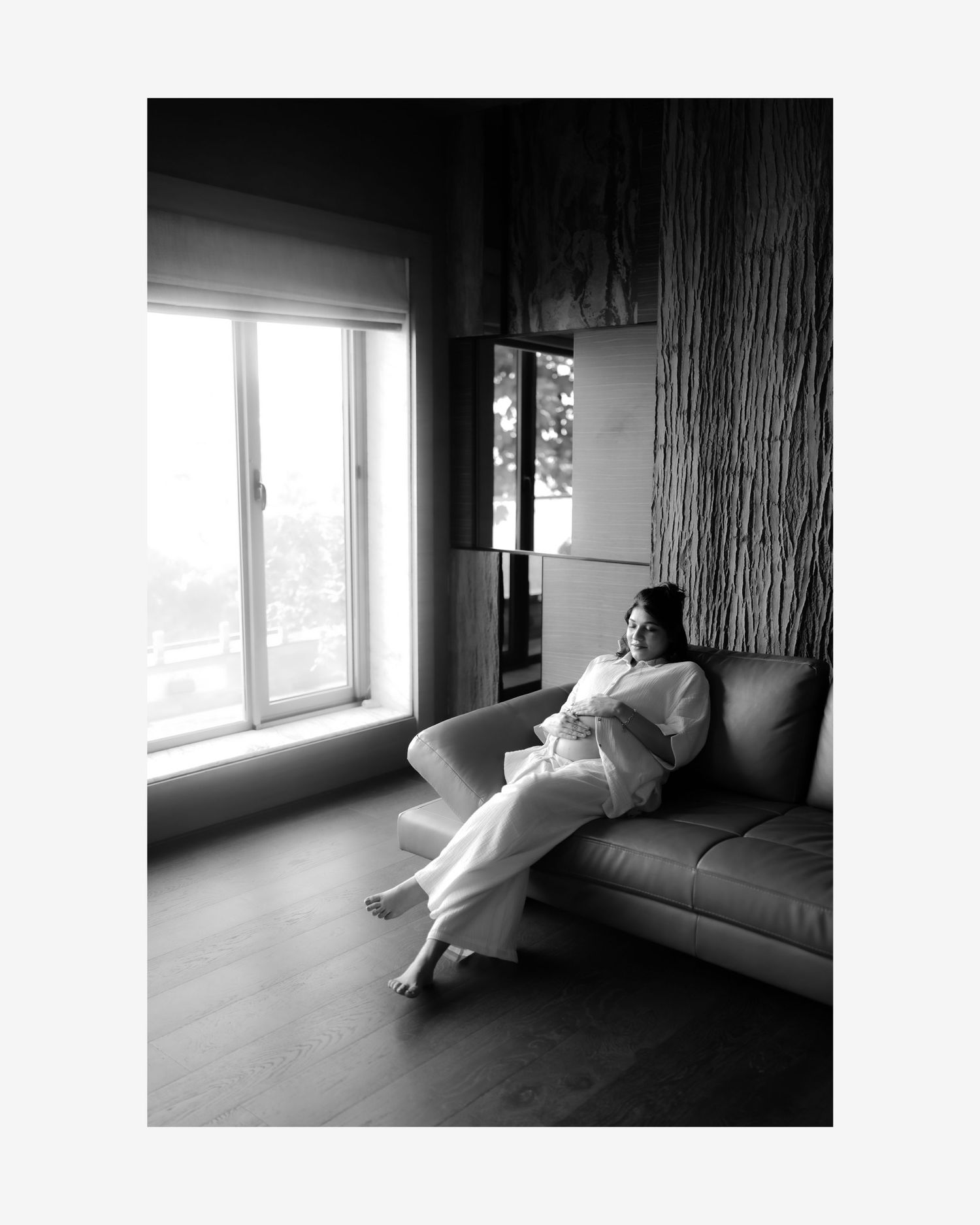 Black and white artistic photo series showing a figure lounging near a bright window in a minimalist interior.