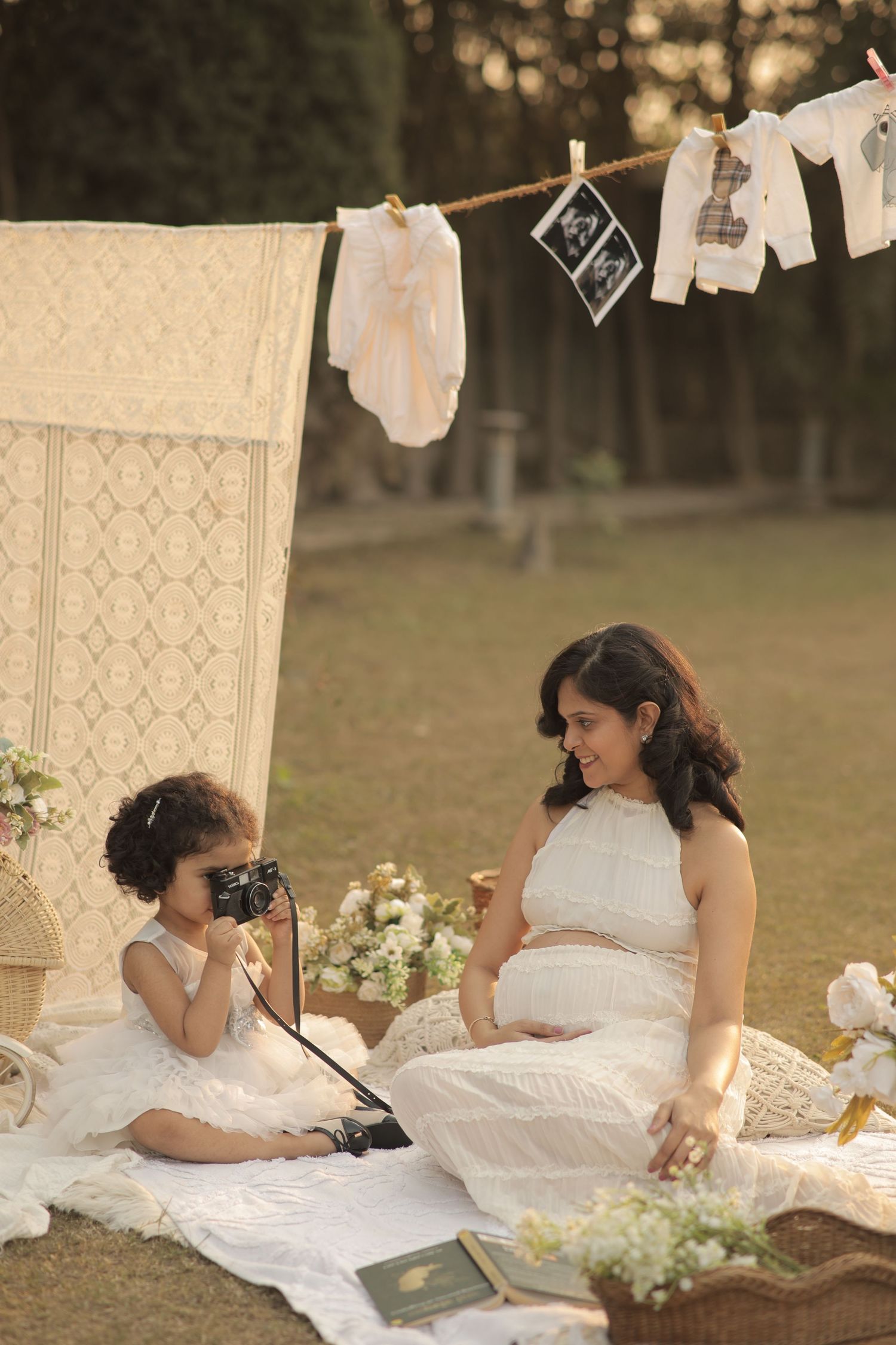 A series of romantic outdoor maternity photos showing a woman in white dress reading and relaxing on a blanket.