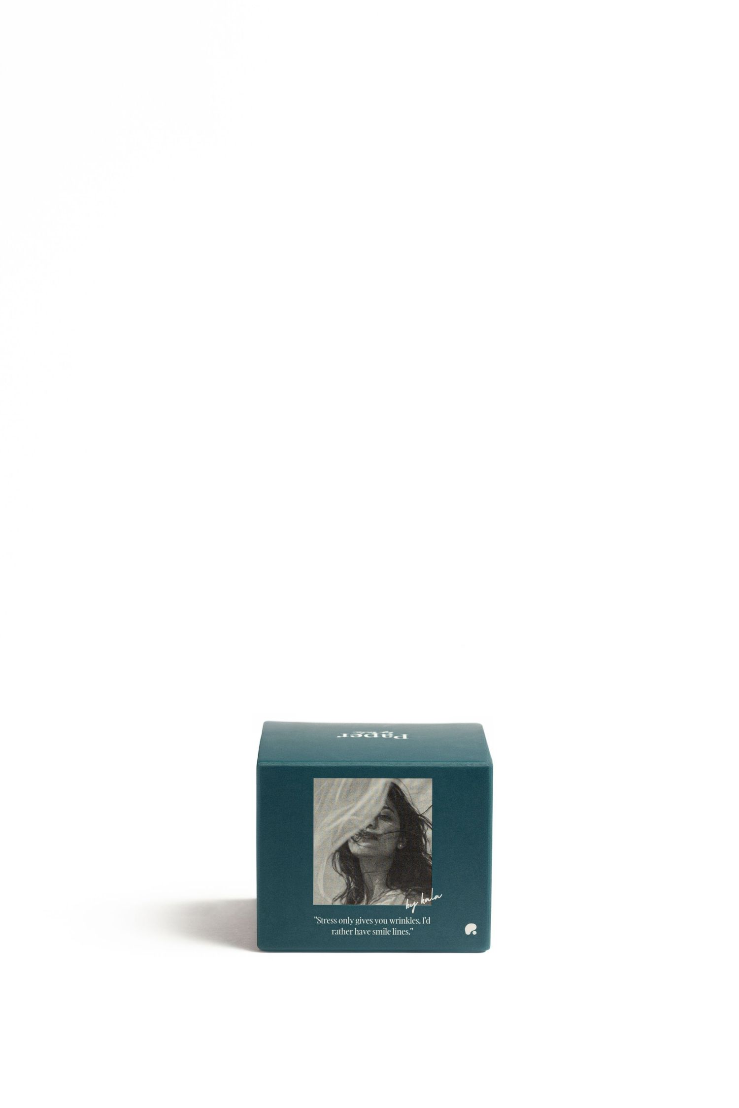 Small dark teal square gift box with a black-and-white portrait of a woman with flowing hair and a handwritten quote on the front.