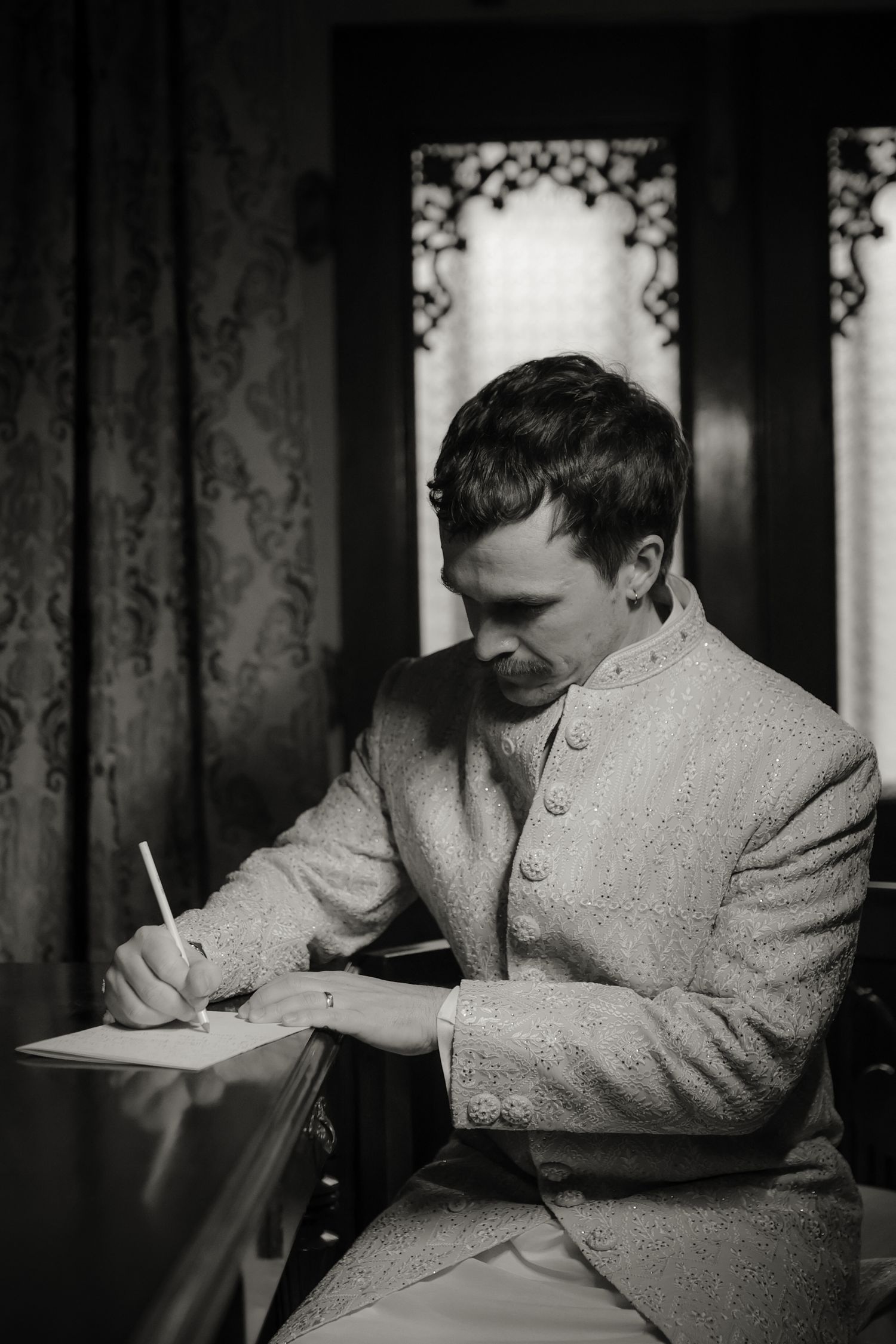 A series of black and white photographs showing someone writing or working at a desk in vintage attire.