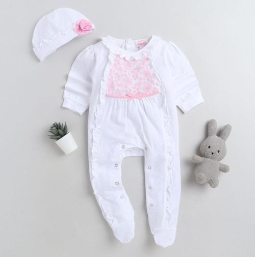White baby onesies with pink accents and a small plush bunny displayed on light background.