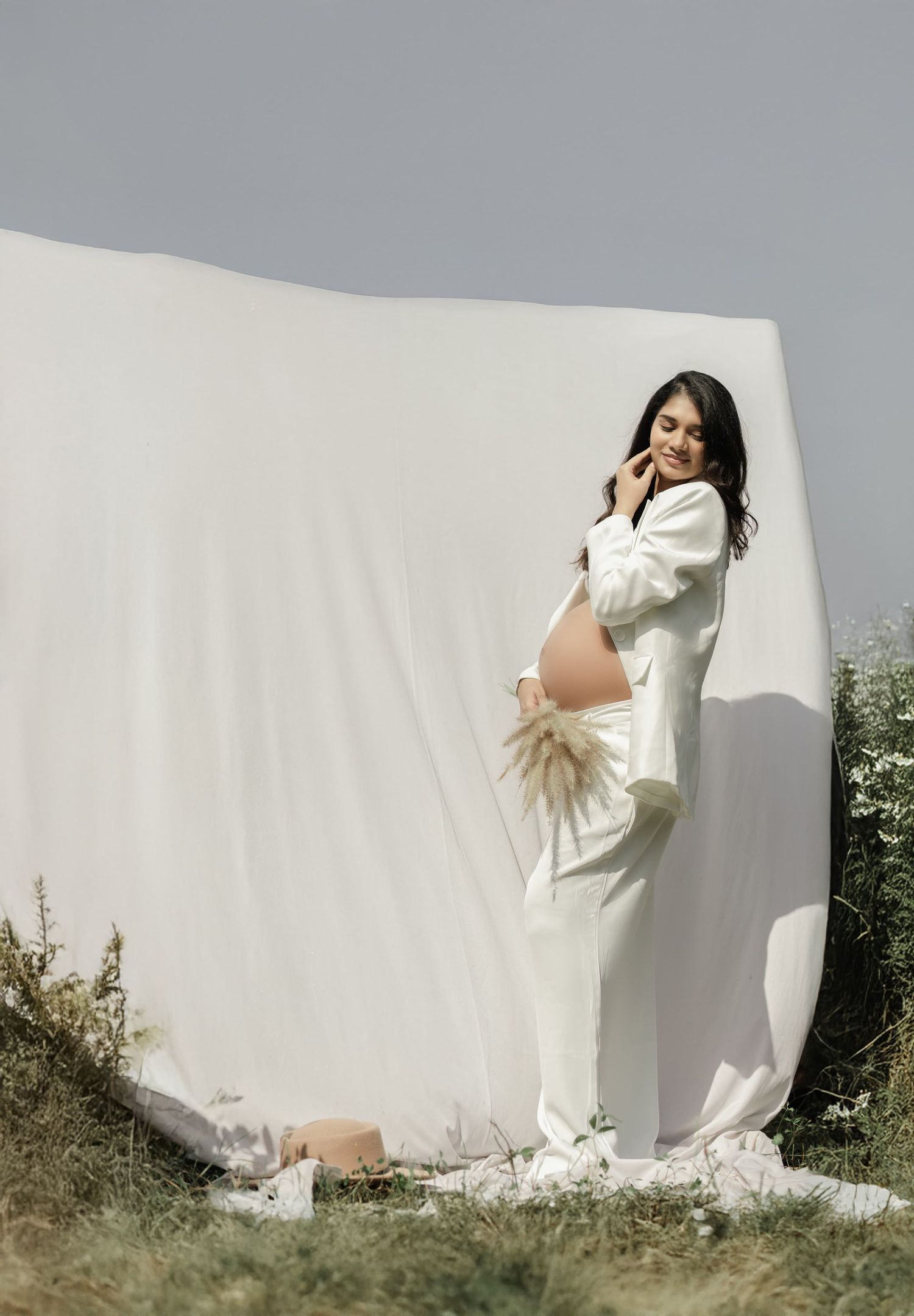 Artistic outdoor portraits against white fabric backdrop in natural setting.