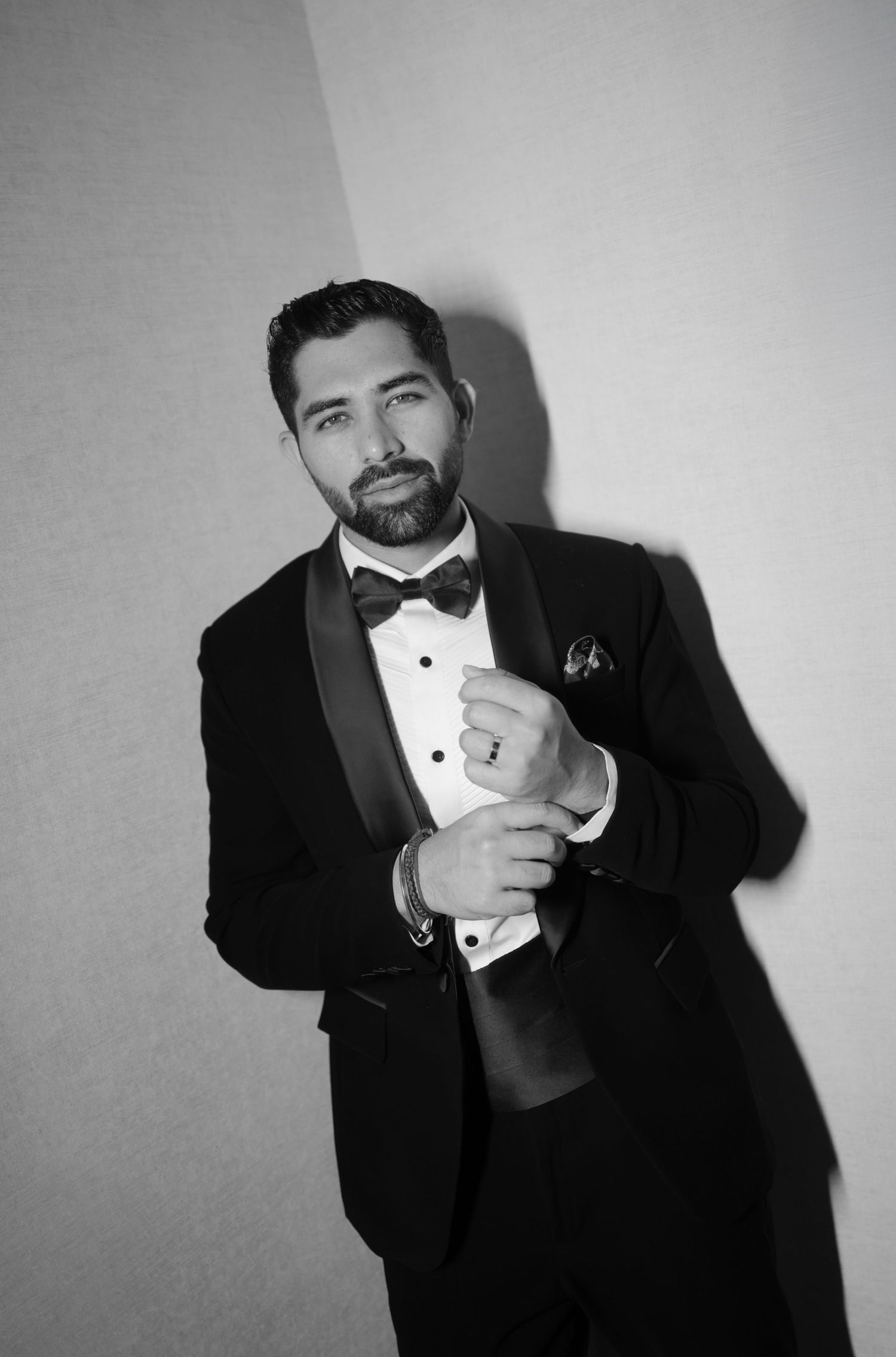 Black and white photo series of someone in a tuxedo striking dramatic poses.