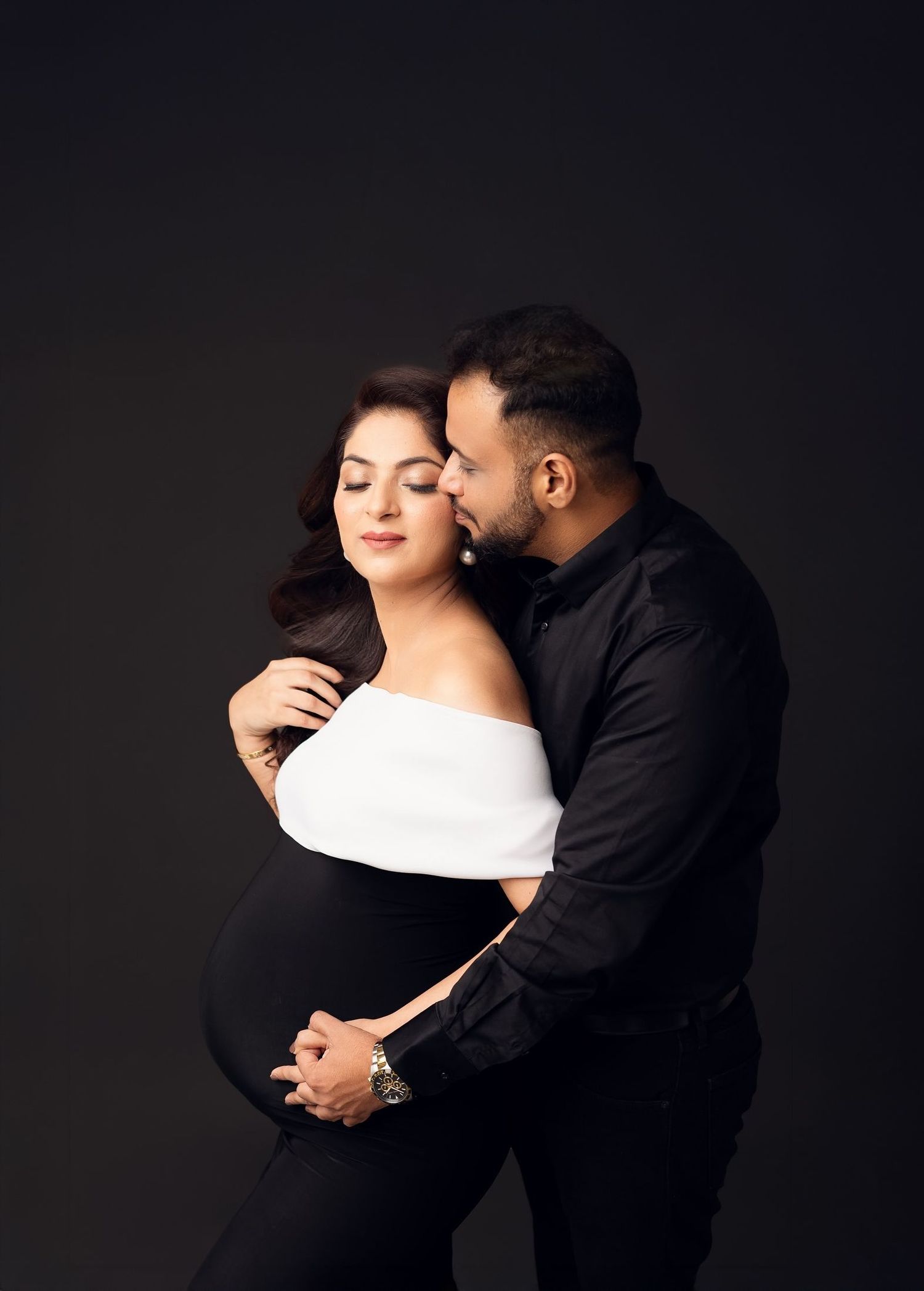 Intimate black and white maternity photos of couple embracing.