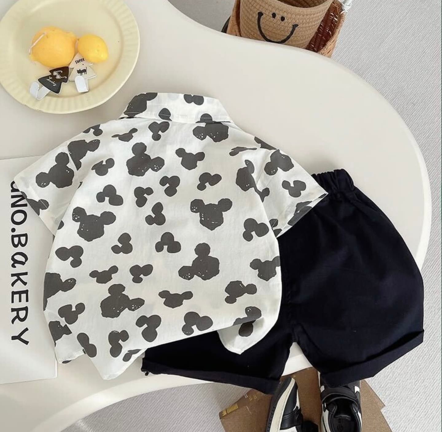 Black and white Mickey Mouse pattern fabric with decorative bows in a lifestyle setting.