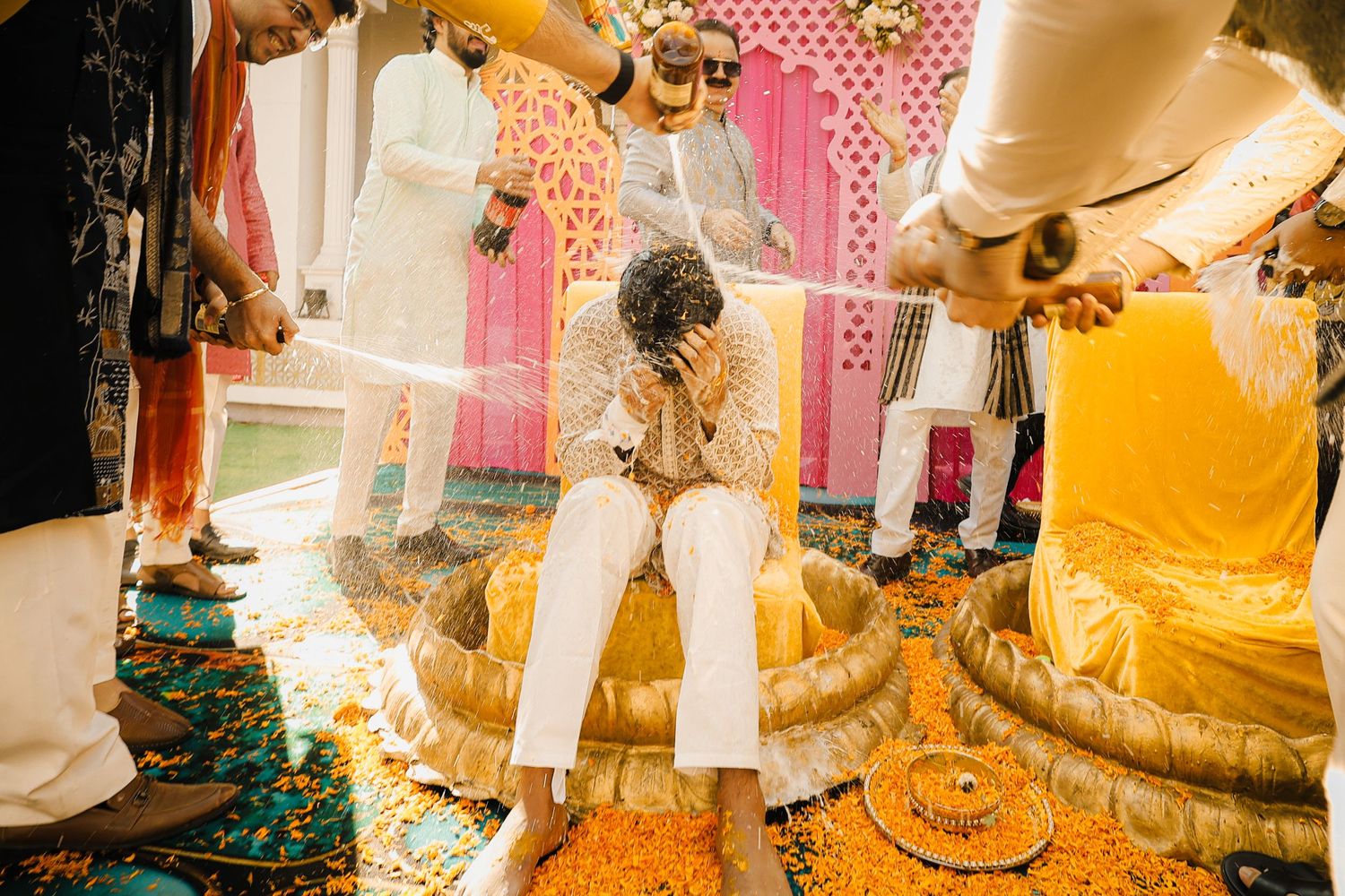 Traditional Thai wedding ceremony with golden decorations and participants in traditional yellow and white attire.