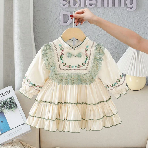 Vintage-style cream dress with floral embroidery and tiered ruffles for young girls.