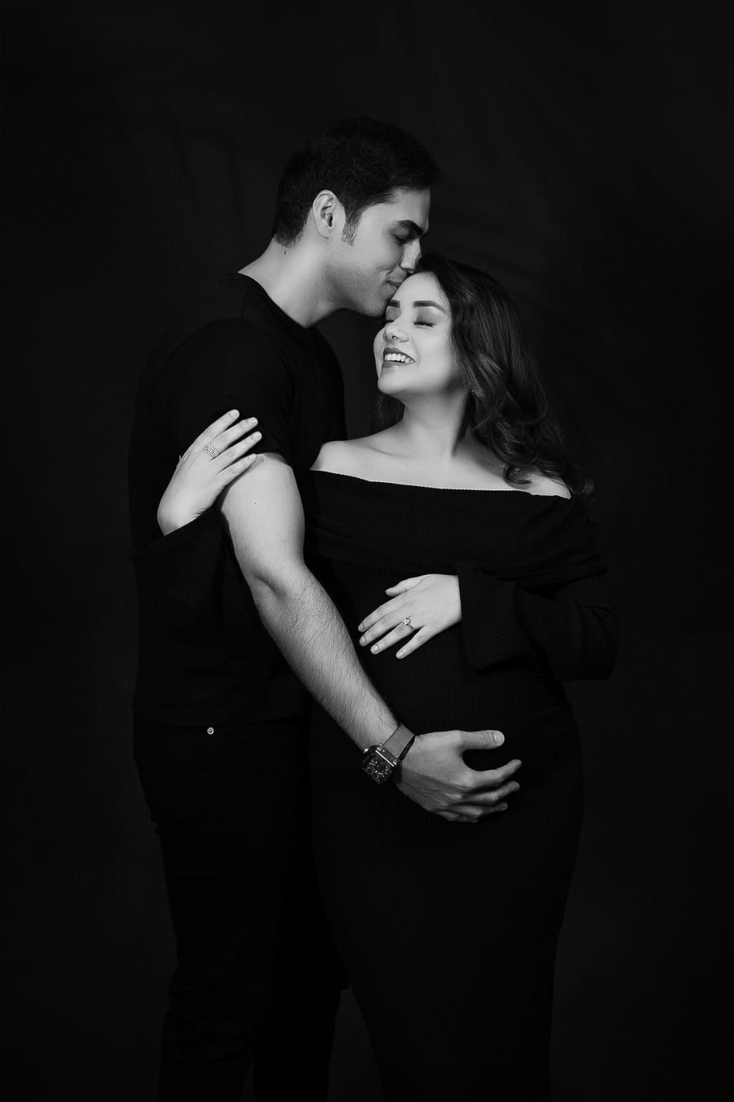 Intimate black and white maternity portrait showing couple embracing.