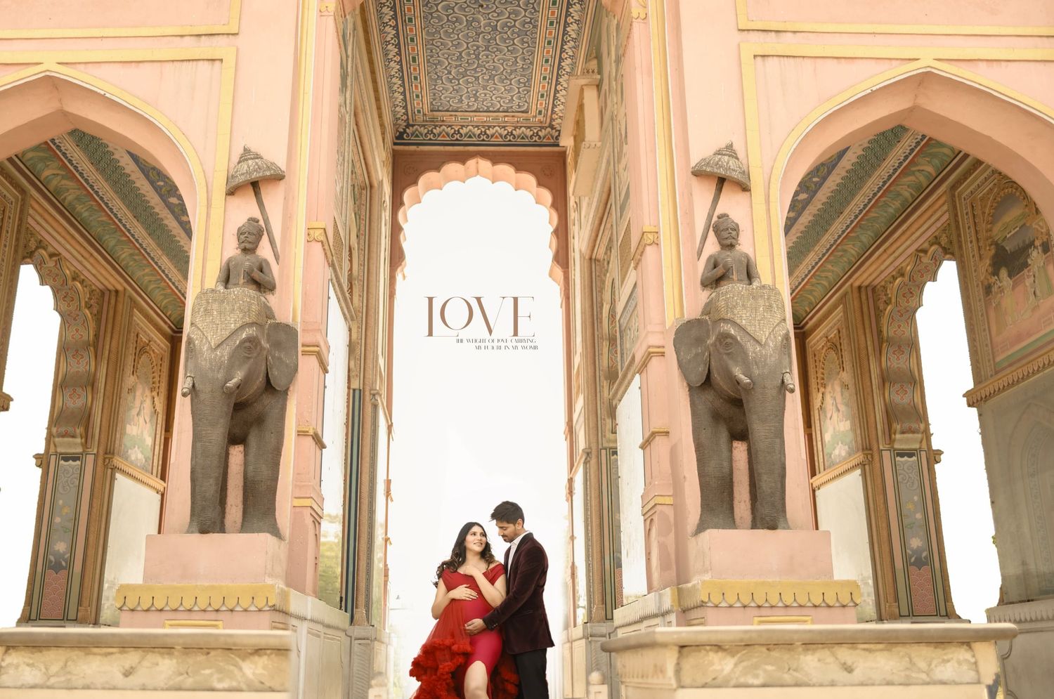 A maternity couple poses elegantly under ornate arches in a classical European-style building's hallways.