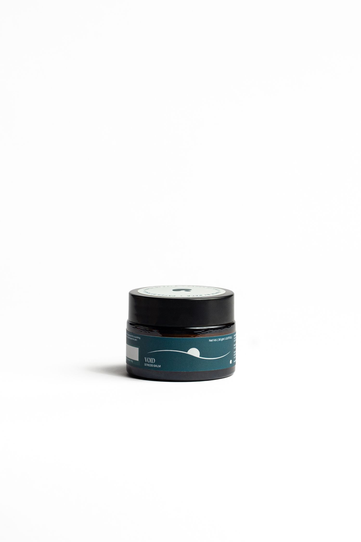 Small dark glass jar with a black lid and a teal label featuring a wave and moon design, shown against a clean white background.