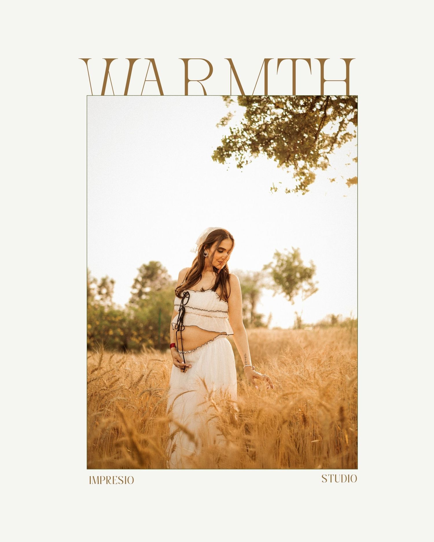 Pregnant woman in white dress standing in golden wheat field, warm sunlight, maternity photography by Impresio Studio.