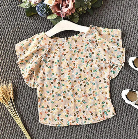 Floral print peach-colored baby dress with short sleeves displayed on a gray backdrop.