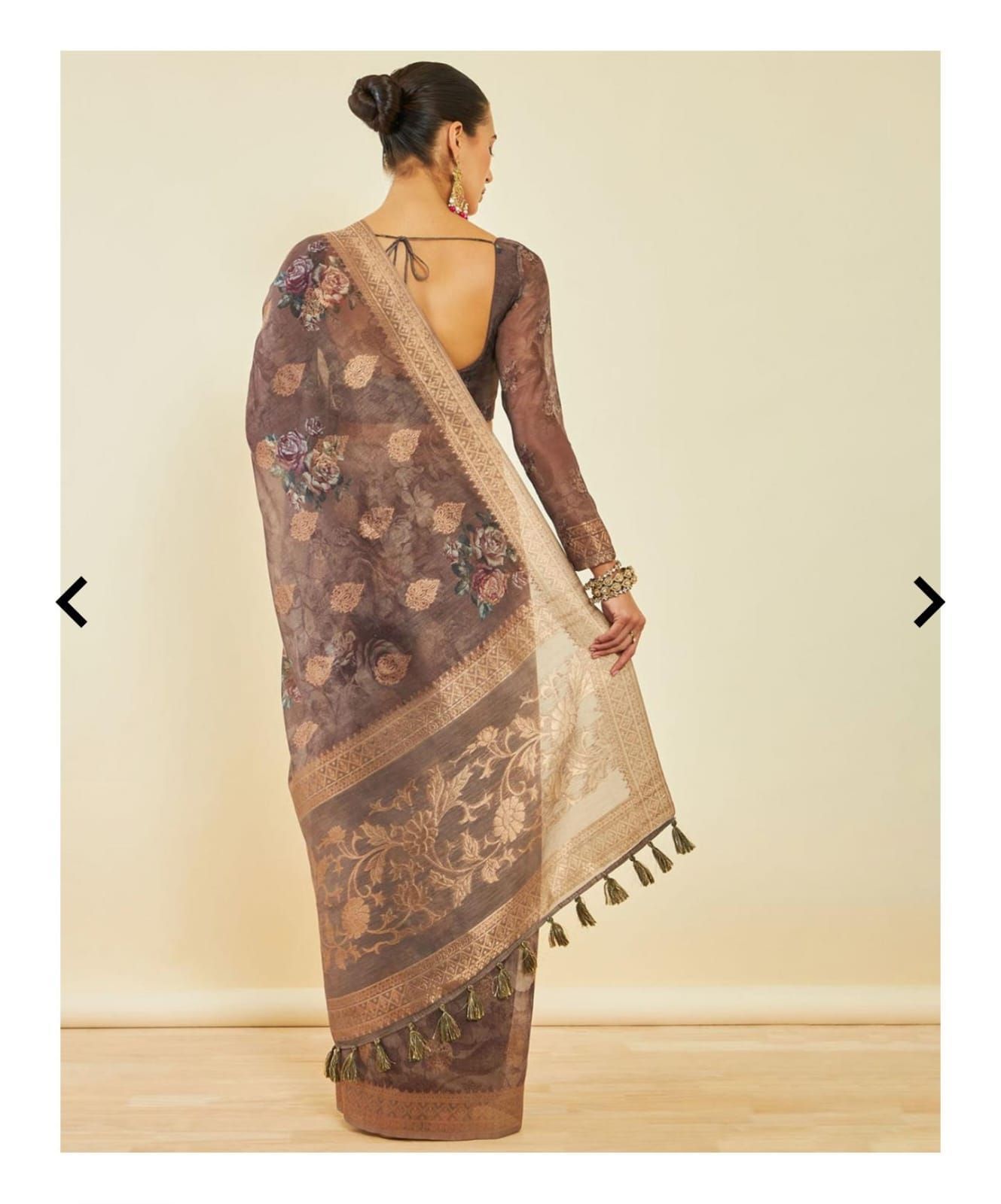 Brown floral print saree with metallic border displayed against neutral background.