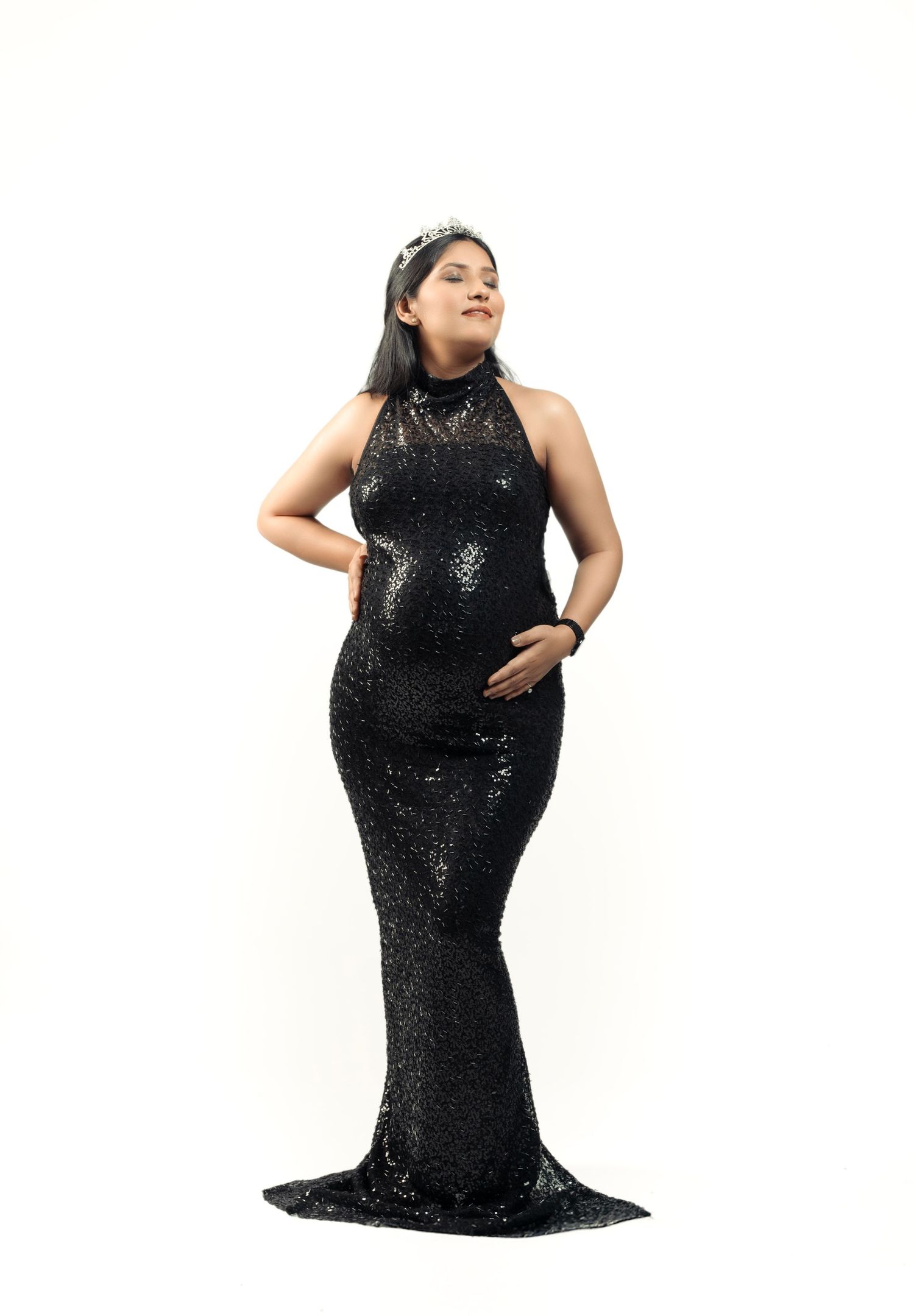 Artistic black and white maternity series showing flowing dress against white backdrop.