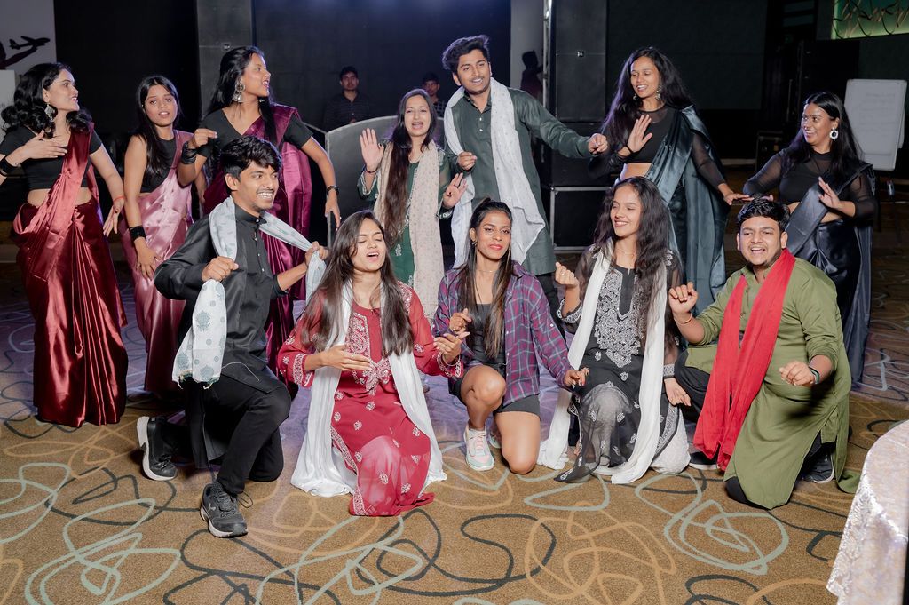 Large group of party guests lined up in formal attire at a festive indoor celebration.