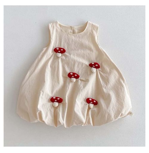 Cream colored sleeveless baby dress decorated with red mushroom appliques.