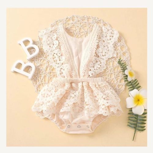 Vintage-style lace baby romper in cream color with delicate floral embroidery.
