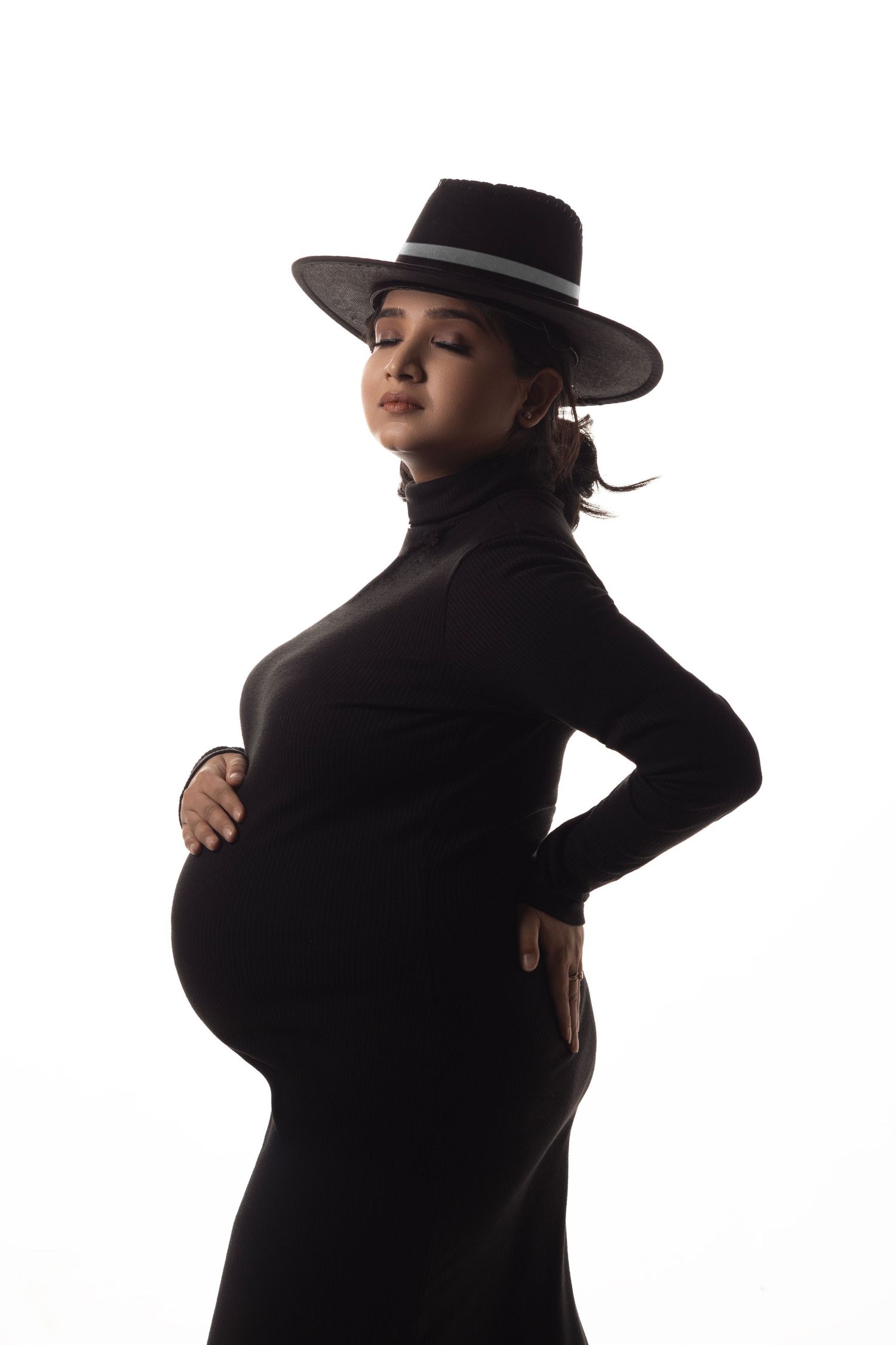 Dramatic fashion poses in black outfits with wide-brimmed hats against white backdrop.
