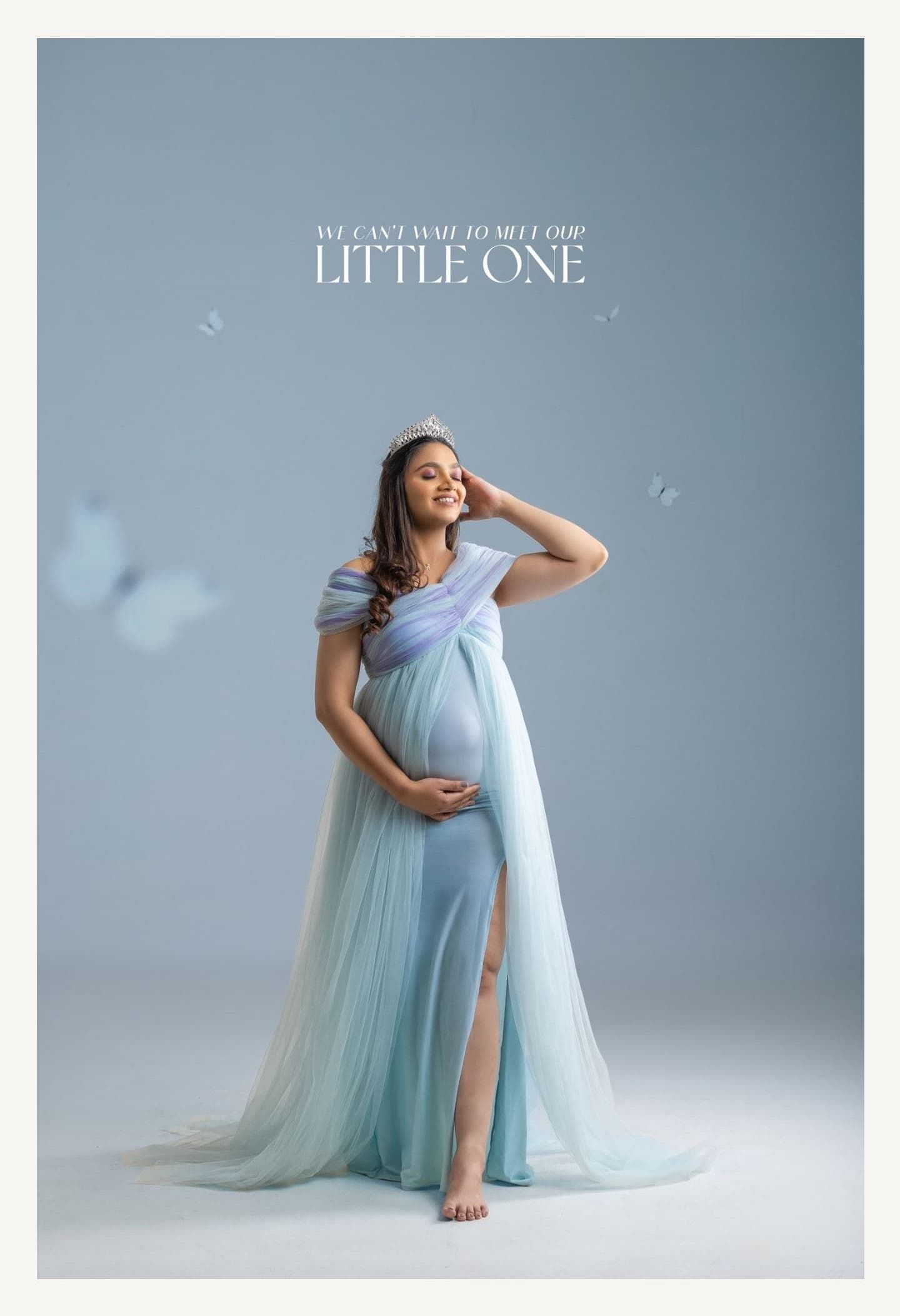 Elegant maternity portraits featuring ethereal blue gown and soft studio lighting.