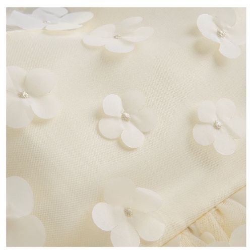 Close-up texture of cream fabric with delicate 3D flower appliques.