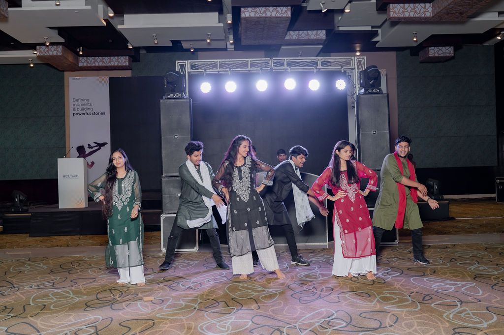 People performing on stage with theatrical lighting and props during a dramatic scene.
