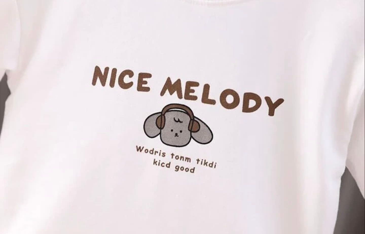 Vintage store merchandise rack displaying t-shirts with text prints and graphics against a white background.