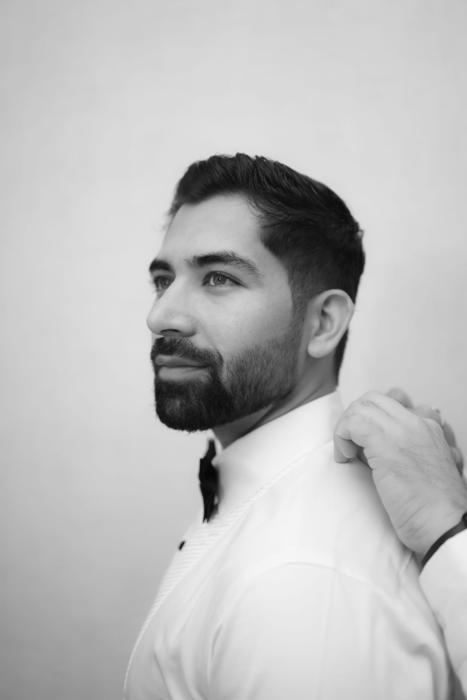 A series of black and white profile portraits showing someone in a white shirt looking upward with a bearded face.