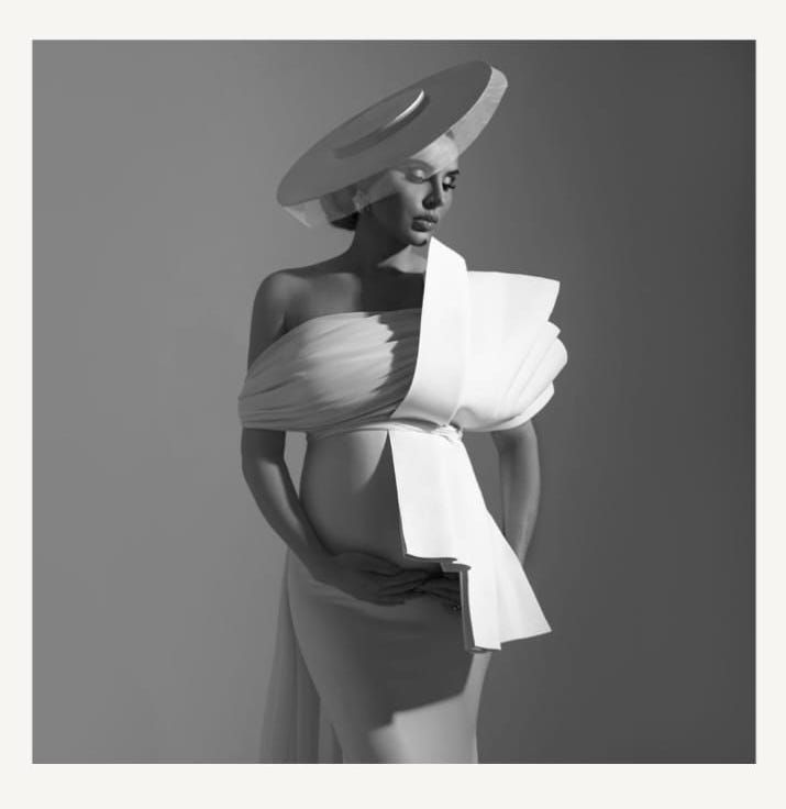 High contrast black and white fashion portrait with dramatic lighting and flowing fabric.