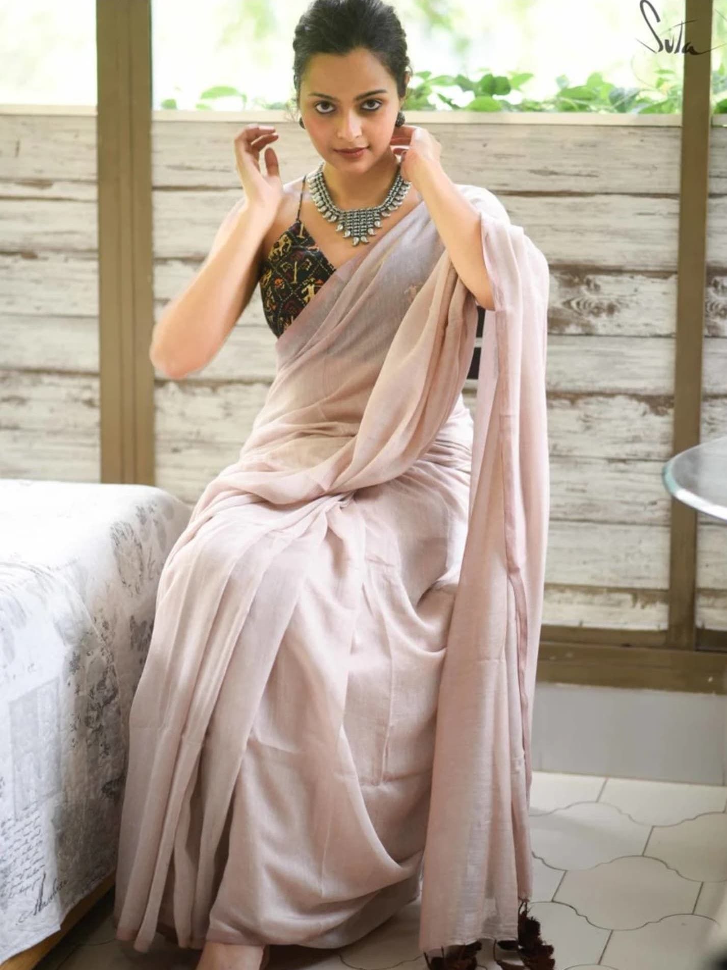 Light pink silk saree adorned with traditional silver jewelry.