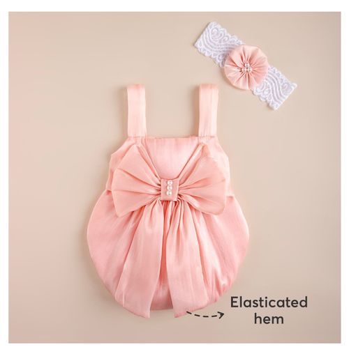 Pink baby romper with large bow detail and matching headband accessory.