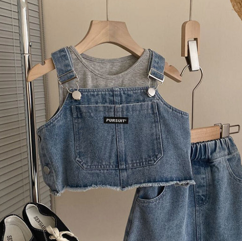Blue denim overalls crop top and matching shorts hanging on wooden hangers.