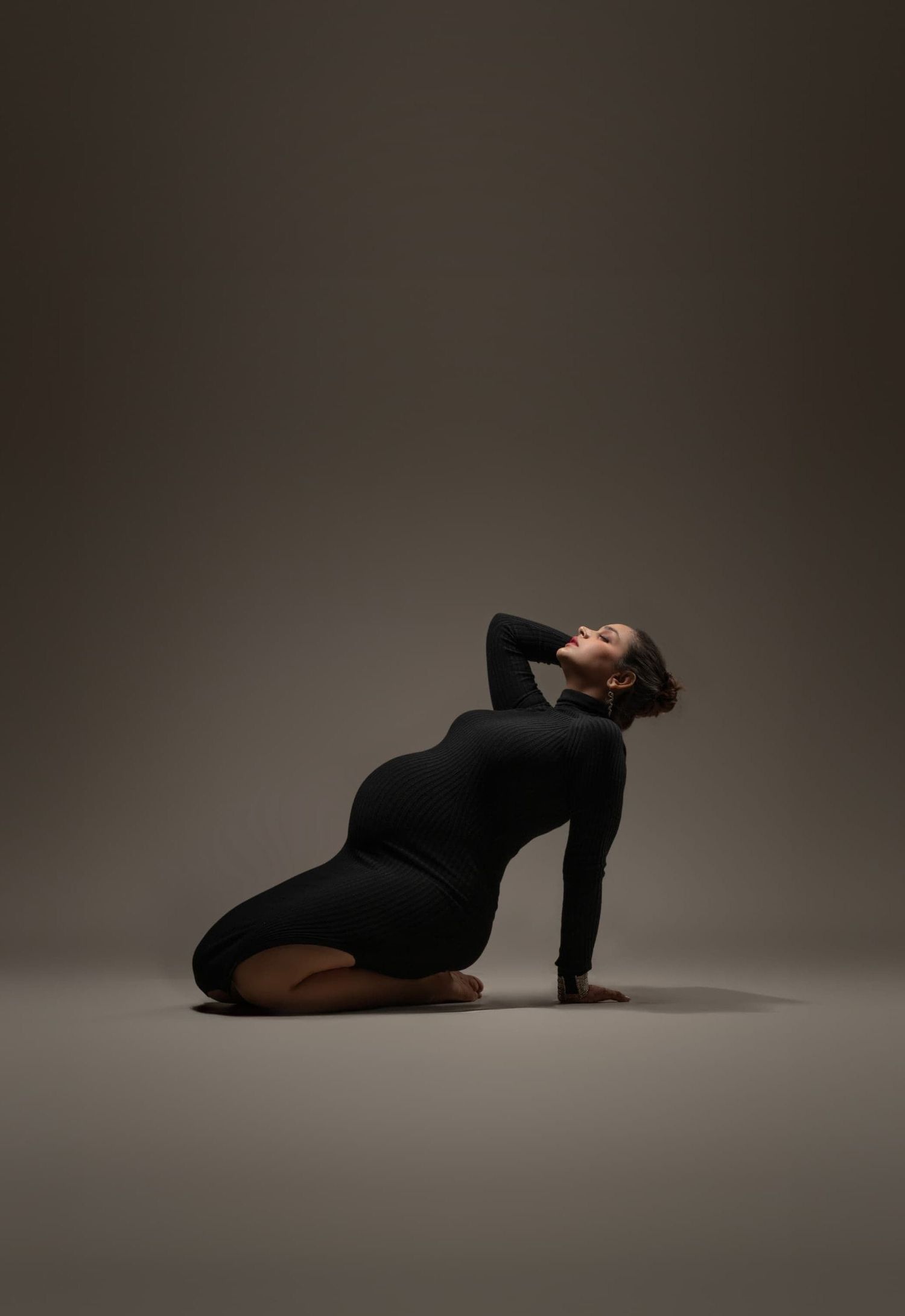 Moody studio portraits showcasing graceful poses on a dark background.