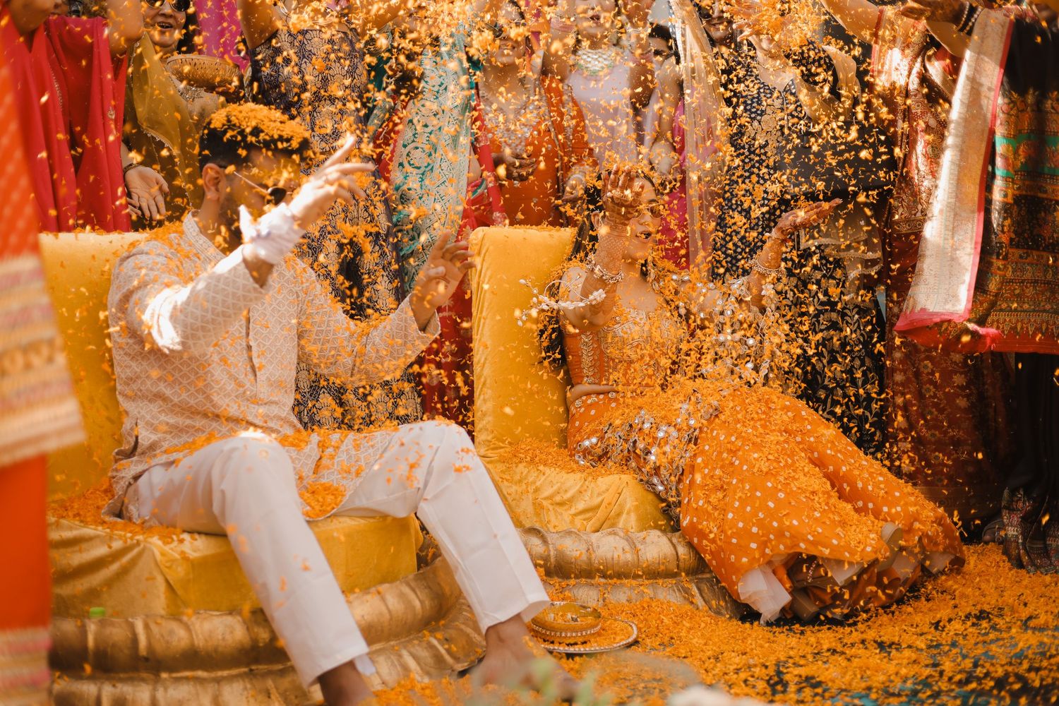 Autumn wedding celebration with orange confetti falling on white dress and shoes against rustic wooden background.