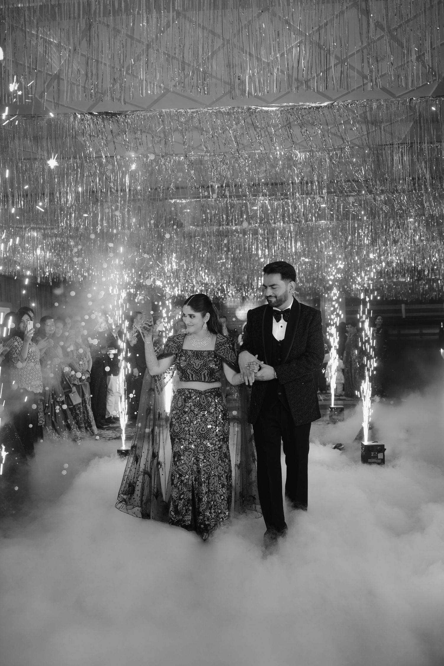 Couples dancing on a misty dance floor with sparklers and special effects creating a dreamy atmosphere at an elegant event.