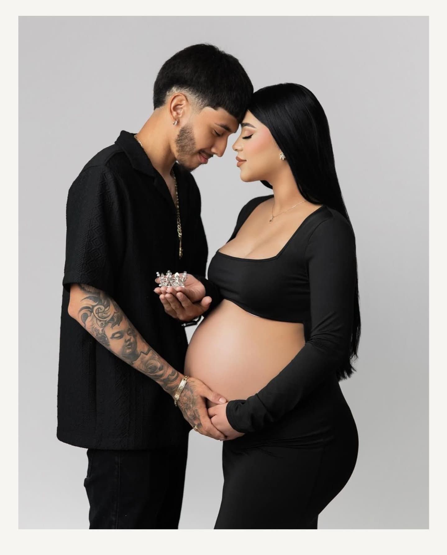 Intimate maternity studio portraits featuring couple in black outfits against grey backdrop.