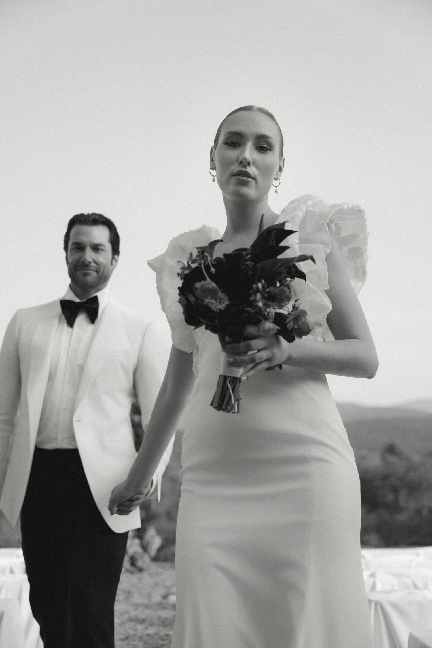 A stylish black and white wedding photo series showing couples in formal attire against a minimalist background.