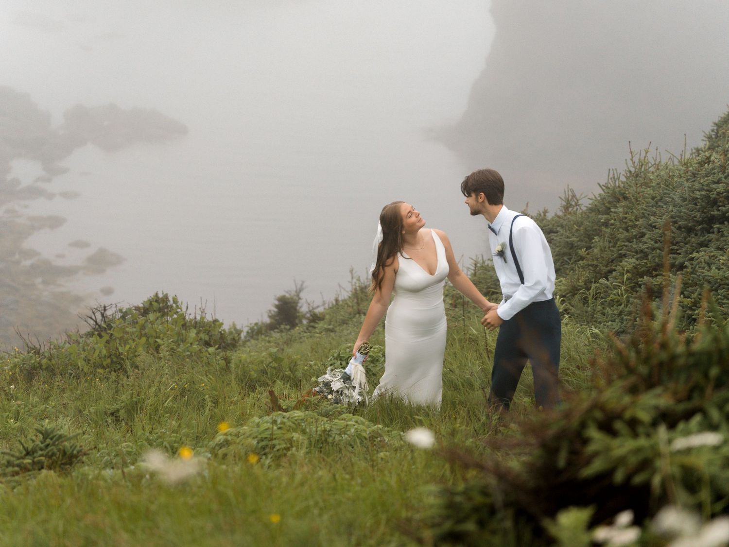 Misty green cliffs overlooking the ocean on an overcast day.
