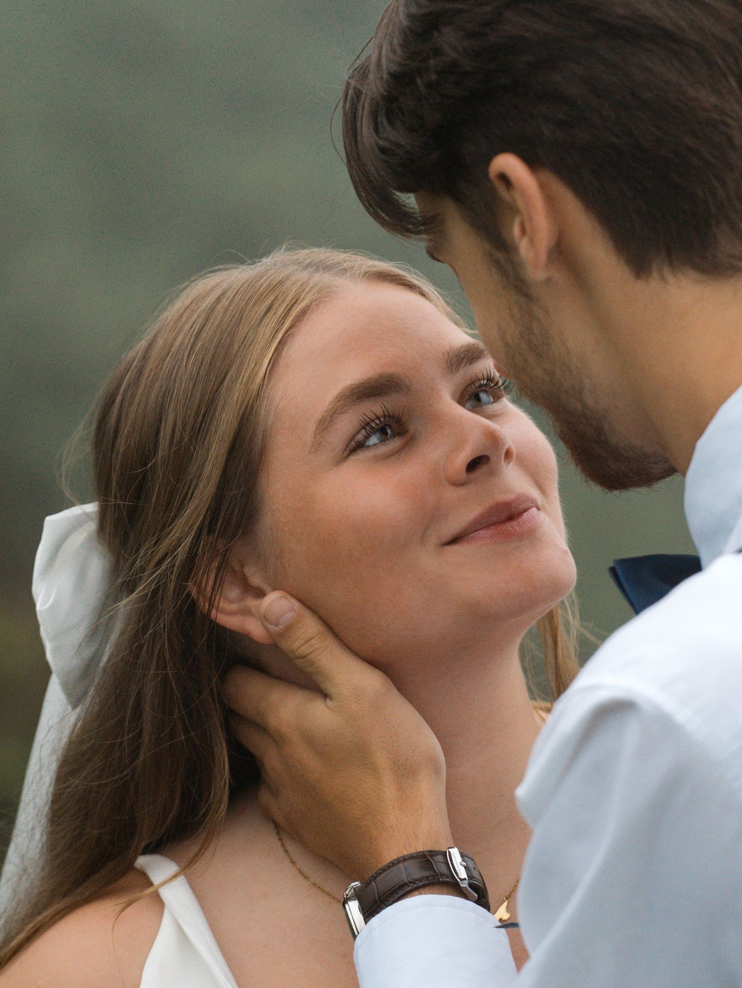 Close up view of a couple sharing an intimate moment against a blurred natural background.
