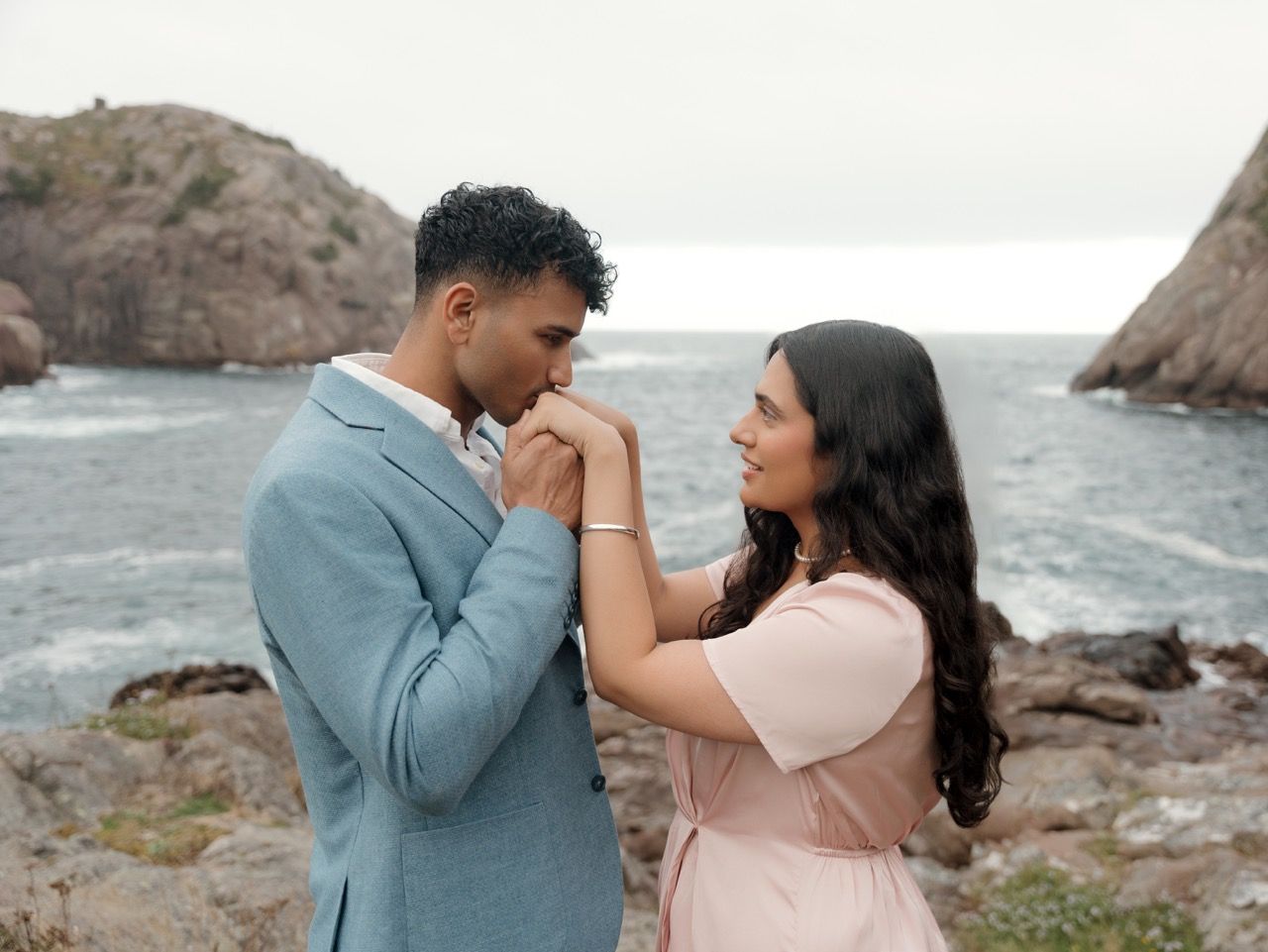 A couple shares tender romantic moments by the rocky coastline in a series of intimate engagement photos.