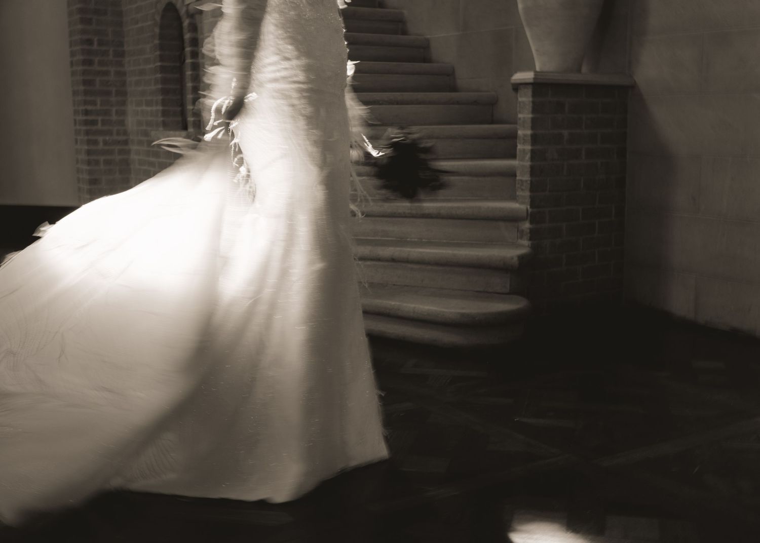 A series of artistic black and white wedding dress photos showing flowing movement on a staircase.