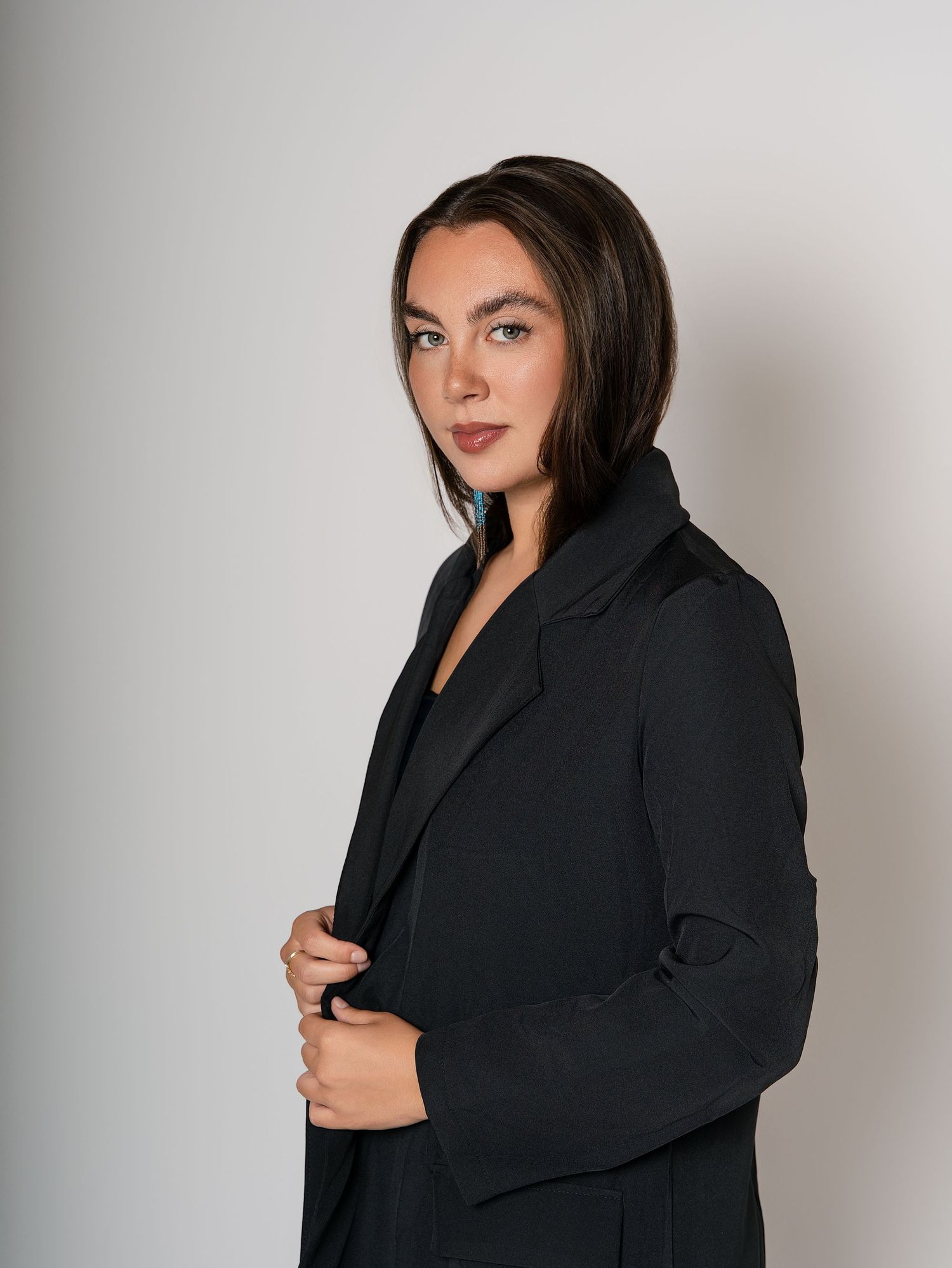 Fashion photography series featuring model in black oversized blazer against white background.