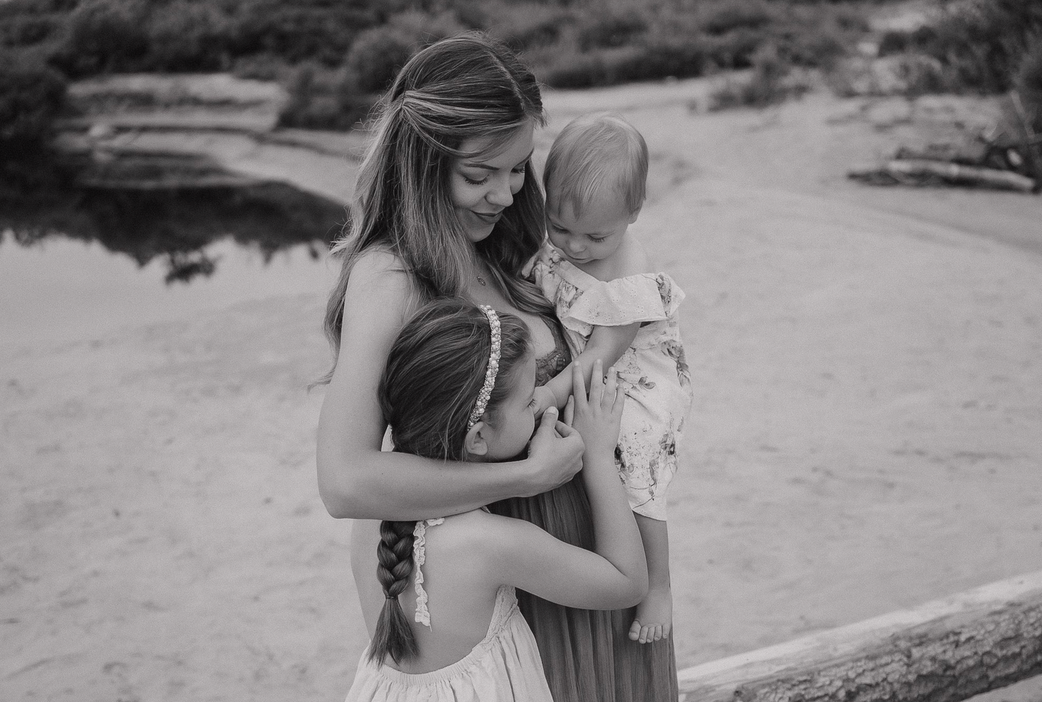 A tender black and white portrait of parent and child sharing an intimate outdoor moment.